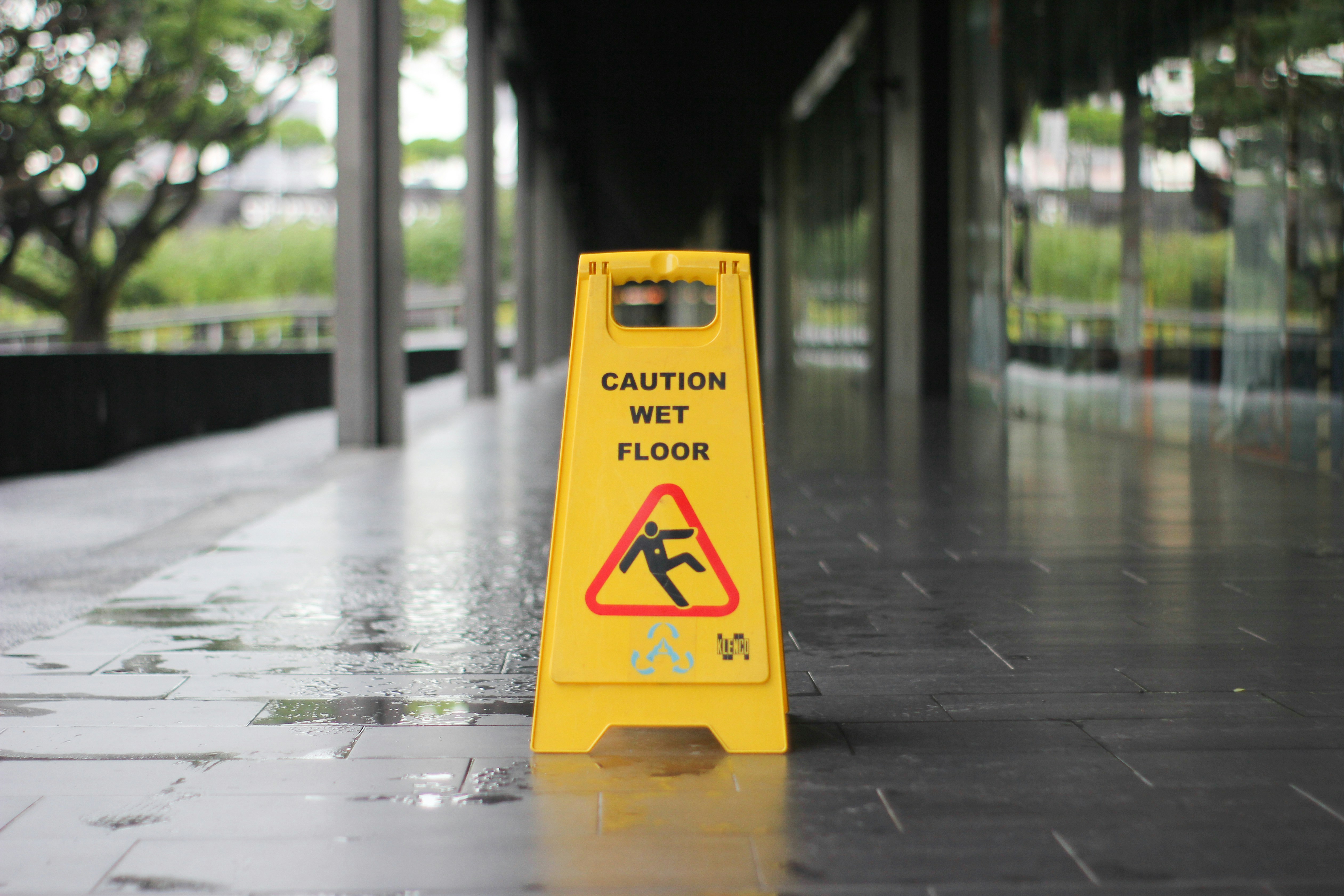 Wet Floor Sign Photo photo of wet floor sign placed over wet, grey concrete